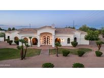 Stunning single-story home boasts arched windows, a decorative front door, and mature landscaping at 3126 E Fruitvale Ct, Gilbert, AZ 85297
