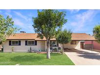 Charming home with lush front yard, mature trees and covered parking at 4122 W Las Palmaritas Dr, Phoenix, AZ 85051