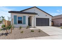 Charming home featuring a two-car garage, desert landscaping, and eye-catching blue shutters on the front window at 42510 W Peters Dr, Maricopa, AZ 85138