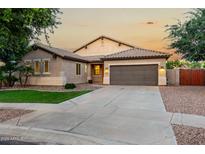 Charming single-story home featuring a neutral color palette, tile roof, and a well-manicured front lawn at 4326 E Cloudburst Ct, Gilbert, AZ 85297