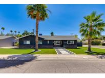 Inviting single-story home with well-manicured lawn, palm trees, stone accents, and a welcoming walkway at 4435 N 35Th St, Phoenix, AZ 85018