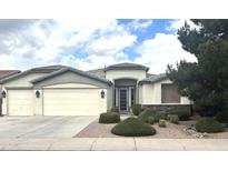 Charming single-story home with a three-car garage and well-manicured front yard landscaping at 8256 W Bloomfield Rd, Peoria, AZ 85381