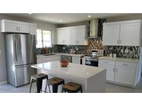 Modern kitchen featuring white cabinets, stainless steel appliances, quartz countertops and decorative backsplash at 8750 E Starlight Way, Scottsdale, AZ 85250