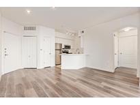 Bright living room featuring wood floors and an open-concept kitchen with stainless steel appliances at 1701 E Colter St # 491, Phoenix, AZ 85016