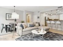 Bright living room featuring a modern couch, stylish rug, and open floor plan to kitchen and dining area at 17850 N 68Th St # 2138, Phoenix, AZ 85054