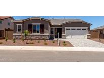 Charming single-story home with stone accents, a two-car garage, and manicured landscaping at 20256 W Monterey Way, Buckeye, AZ 85396