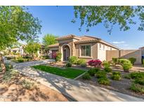 Charming single-story home with beautiful landscaping and a welcoming entrance with a stone archway at 20783 W Pasadena Ave, Buckeye, AZ 85396