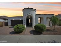 Stunning stucco home featuring a turret entryway, brick driveway, and lush, low-maintenance landscaping at 22964 E Via Del Sol --, Queen Creek, AZ 85142