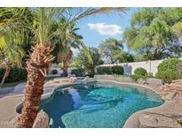 Backyard pool with lush landscaping, rock features, and clear blue water, perfect for relaxation at 3440 E Southern Ave # 1042, Mesa, AZ 85204