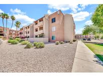 Attractive condominium building featuring multiple stories, desert landscaping, palm trees, and a well-maintained walkway at 540 N May St # 1109, Mesa, AZ 85201