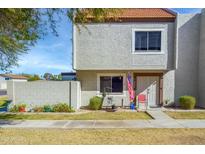 Inviting two-story townhouse with a well-maintained lawn and charming front patio area at 1032 E Redfield Rd, Tempe, AZ 85283