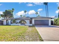Attractive single-story home featuring a well-maintained lawn, modern design, a garage door, and desert landscaping at 10844 N 37Th Way, Phoenix, AZ 85028