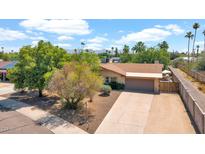 Charming single-story home with a well-manicured lawn and mature trees, creating a welcoming curb appeal at 11011 N 39Th St, Phoenix, AZ 85028