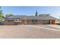 Charming single-story brick home featuring a low-maintenance gravel yard and covered carport at 1235 E Dover St, Mesa, AZ 85203