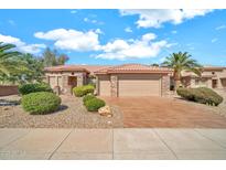 Charming home featuring a three-car garage, desert landscaping, and a red tile roof at 15101 W Waterford Dr, Surprise, AZ 85374