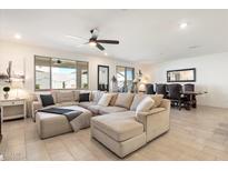Spacious living area with a large sectional couch and sliding glass doors to the patio at 17140 W Running Deer Trl, Surprise, AZ 85387