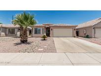 Charming single-story home with desert landscaping, mature palm tree, and a two-car garage at 2813 N 107Th Dr, Avondale, AZ 85392