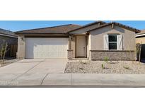 Charming single-story home featuring a two-car garage and a beautifully landscaped front yard with stone accents at 37427 W San Sisto Ave, Maricopa, AZ 85138