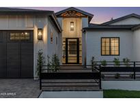 Stunning home exterior featuring a modern design, black framed windows, and a welcoming entrance at twilight at 3848 E Fairmount Ave, Phoenix, AZ 85018
