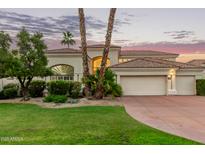 Stunning home featuring a well-manicured lawn, desert landscaping, and a three-car garage at 7376 E Via Estrella Ave, Scottsdale, AZ 85258