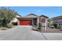 Charming single-story home featuring a red garage door and desert landscaping under a clear blue sky at 13487 W Buckskin Trl, Peoria, AZ 85383