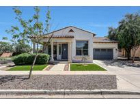 Charming single-story home featuring a tile roof, manicured landscaping, and attached two-car garage at 15407 W Windrose Dr, Surprise, AZ 85379
