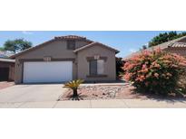 A charming single-story home featuring a well-maintained lawn and an attached two-car garage at 15905 W Saguaro Ln, Surprise, AZ 85374