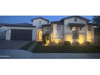 Inviting single-story home with lush lawn, stone accents, an arched entry, and a two car garage at 2121 E Aquarius Pl, Chandler, AZ 85249