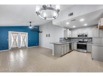 Bright living room adjacent to kitchen features neutral colors, ceiling fan, and access to backyard patio at 3178 W Williams Dr, Phoenix, AZ 85027