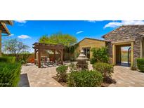 Inviting backyard patio featuring a fireplace, pergola, water feature, and desert landscaping at 36813 N 109Th Way, Scottsdale, AZ 85262