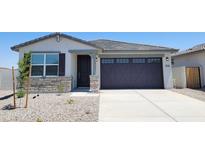 Inviting single-story home with desert landscaping, stone accents and a modern garage door at 37168 W Prado St, Maricopa, AZ 85138