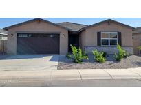 Charming single-story home with a dark garage door, desert landscaping, and neutral colored facade at 37174 W La Paz St, Maricopa, AZ 85138