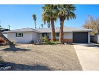 Charming single-story home with desert landscaping and mature palm trees at 4714 N Miller Rd, Scottsdale, AZ 85251
