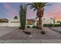 Charming single-story home featuring desert landscaping, gravel, and a well-maintained yard at sunset at 6119 E Sandra Ter, Scottsdale, AZ 85254