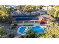 Stunning aerial view of backyard oasis featuring sparkling pool, solar panels, and lush landscaping at 6615 E Desert Cove Ave, Scottsdale, AZ 85254