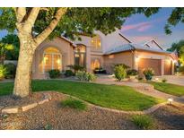 Charming home exterior featuring landscaped yard, garden, greenery, and a two-car garage at 1073 N Layman St, Gilbert, AZ 85233