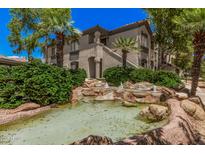 Attractive building with landscaped water feature, mature trees, and charming architectural details at 15095 N Thompson Peak Pkwy # 1005, Scottsdale, AZ 85260