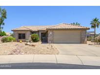 Charming single-story home featuring a desert landscape, beige exterior paint, and a two-car garage at 15658 W Arbor Trl, Surprise, AZ 85374
