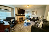Cozy living room featuring a brick fireplace, modern furnishings, and a comfortable seating area at 2060 N Center St # 275, Mesa, AZ 85201