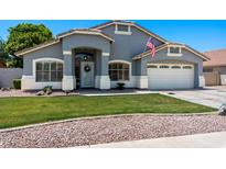 Charming single-story home with well-manicured lawn and a two-car garage at 2111 E Rawhide St, Gilbert, AZ 85296