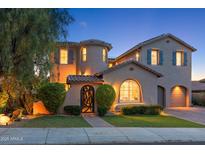 Elegant two-story home featuring a circular tower, arched entryway, dark shutters and a manicured lawn at 26036 N 85Th Dr, Peoria, AZ 85383