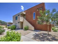 Attractive two-story condo with a stucco exterior, low maintenance landscaping, and a bright blue sky at 3600 N Hayden Rd # 2310, Scottsdale, AZ 85251