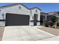 Charming single-Gathering home featuring a stucco exterior, a two-car garage, and an inviting front entrance at 40918 W Hillman Dr, Maricopa, AZ 85138