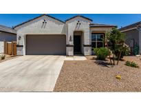Charming single-story home featuring a neutral color palette, desert landscaping, and a two-car garage at 40918 W Hillman Dr, Maricopa, AZ 85138