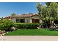 Charming home featuring neat landscaping, green grass, trimmed hedges and a decorative tree in the front yard at 4318 N 180Th Dr, Goodyear, AZ 85395