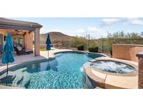 Inviting pool and spa with beautiful mountain views and covered outdoor seating area at 13072 W Alyssa Ln, Peoria, AZ 85383