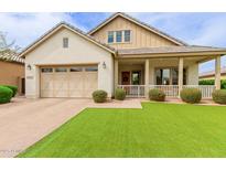 Charming single-Gathering home featuring a welcoming front porch, desert landscaping, and a two-car garage at 14360 W Windrose Dr, Surprise, AZ 85379