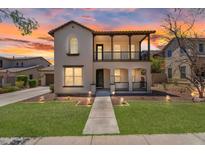 Charming two-story home showcasing stucco finish, landscaped lawn, covered balcony, and inviting curb appeal at sunset at 20507 W Daniel Pl, Buckeye, AZ 85396