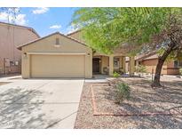 Charming single-story home featuring a spacious front yard, a two-car garage, and a cozy front porch at 23787 W Yavapai St, Buckeye, AZ 85326
