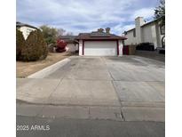 Charming single-story home with a spacious driveway and solar panels on the roof at 2533 N 88Th Ln, Phoenix, AZ 85037